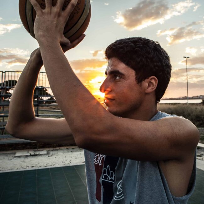 boy plays-basketball-at-sunset