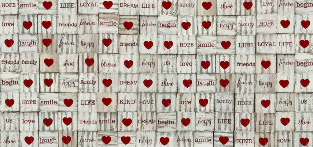 Rustic wooden background with red hearts and uplifting words for love and happiness themes.